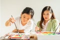 cute little children hold paintbrush, mix color painting in education classroom, select focus at child. asian beautiful children Royalty Free Stock Photo