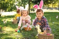 Cute little children hunting eggs in park