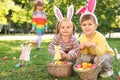 Cute little children hunting eggs in park