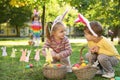 Cute little children hunting eggs in park