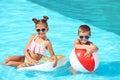 Cute little children with inflatable toys in pool