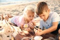 Cute little children looking at sea shells through magnifying glass on beach Royalty Free Stock Photo