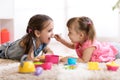 Cute little children playing with kitchenware while lying on floor at home Royalty Free Stock Photo