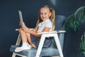 Cute little girl playing with tablet. Happy blondy girl at home. Funny lovely girl having fun in kids room Royalty Free Stock Photo