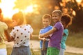 Cute little children playing tug of war game in park at sunset Royalty Free Stock Photo