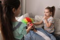 Cute little children putting clown nose and wig on father while he sleeping at home