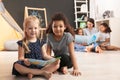 Cute little children reading book on floor in kindergarten. Indoor activity Royalty Free Stock Photo