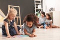 Cute little children reading book on floor in kindergarten. Indoor activity Royalty Free Stock Photo