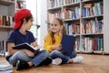 Cute little children reading books on floor