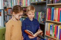 Cute little children reading books in library. Concept of studying, back to school and friends Royalty Free Stock Photo