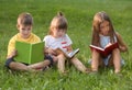 Cute little children reading books in park on summer day Royalty Free Stock Photo