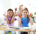 Cute little children showing painted hands at lesson indoors