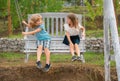 Cute little children swinging outdoors. Portrait of two happy young kids at the spring park. Cute lovely boy and girl in Royalty Free Stock Photo