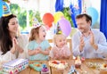 Cute little children twins and their parents having fun and celebrate birthday party with colorful decoration Royalty Free Stock Photo