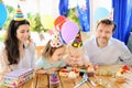 Cute little children twins and their parents having fun and celebrate birthday party with colorful decoration and cake. Royalty Free Stock Photo