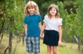 Cute little children walking outdoors. Portrait of two happy young kids at the spring park. Cute lovely boy and girl in Royalty Free Stock Photo