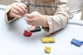 Cute little childrens hands playing at home, molding multi-colored plasticine, sculpts with colored clay stucco. Playdough, clay