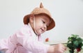 Lovely chinese Baby girl With a hat play flower