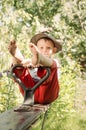 Cute little country boy sitting in a garden Royalty Free Stock Photo