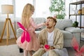 Cute little daughter feeding father during game time at home