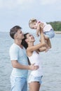 Cute little daughter with her lovely parents at the beach Royalty Free Stock Photo