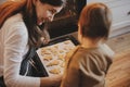 Cute little daughter and mother baking christmas gingerbread cookies in modern scandinavian kitchen. Cute toddler girl and mom Royalty Free Stock Photo