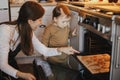 Cute little daughter and mother baking christmas gingerbread cookies in modern scandinavian kitchen. Cute toddler girl and mom Royalty Free Stock Photo