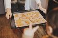 Cute little daughter and mother holding tray with christmas cookies close up in modern kitchen. Cute toddler girl and mom baking Royalty Free Stock Photo