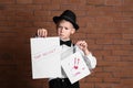 Cute little detective with evidence against brick wall Royalty Free Stock Photo