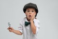 Cute little detective with magnifying glass on grey background