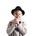 Cute little detective with magnifying glass on white background Royalty Free Stock Photo