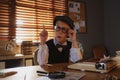 Cute little detective wearing glasses at table in office Royalty Free Stock Photo