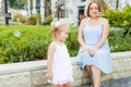 Cute little emotional blondy toddler girl in dress with pregnant mother playing, catching soap bubbles during walk in the city par Royalty Free Stock Photo