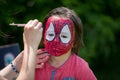 Cute little five years old boy, having his face painted as spid Royalty Free Stock Photo