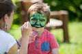 Cute little five years old boy,. having his face painted on his Royalty Free Stock Photo