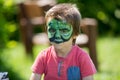 Cute little five years old boy,. having his face painted on his Royalty Free Stock Photo