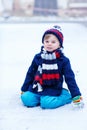 Cute little funny boy in colorful winter clothes having fun with Royalty Free Stock Photo