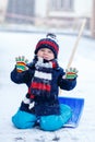 Cute little funny boy in colorful winter clothes having fun with Royalty Free Stock Photo