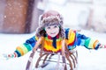 Cute little funny boy in colorful winter clothes having fun with Royalty Free Stock Photo