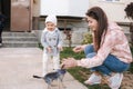 Cute little gilr with her mom play with little dor outside. Yorkshire terrer play and jump. Adorable gilr have fun with