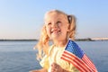 Cute little girl with American flag near river