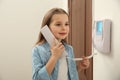 Cute little girl answering intercom call indoors Royalty Free Stock Photo