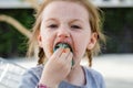 Funny little girl appetizing eating colorful cotton candy