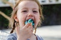 Funny little girl appetizing eating colorful cotton candy