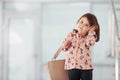 Cute little girl with bag indoors in the office or airport talking by phone Royalty Free Stock Photo