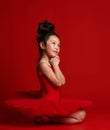 Cute little girl ballerina ballet dancer in beautiful dress is dancing on red Royalty Free Stock Photo