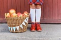 Cute little girl with a basket of red apples on wood background