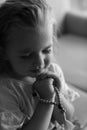 Cute little girl with beads praying indoors Royalty Free Stock Photo