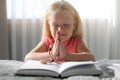 Cute little girl with beads praying over Bible Royalty Free Stock Photo