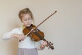 Cute little girl in a beautiful dress playing violin. Joyful and happy emotions. Training. Education. School. Aesthetic training. Royalty Free Stock Photo